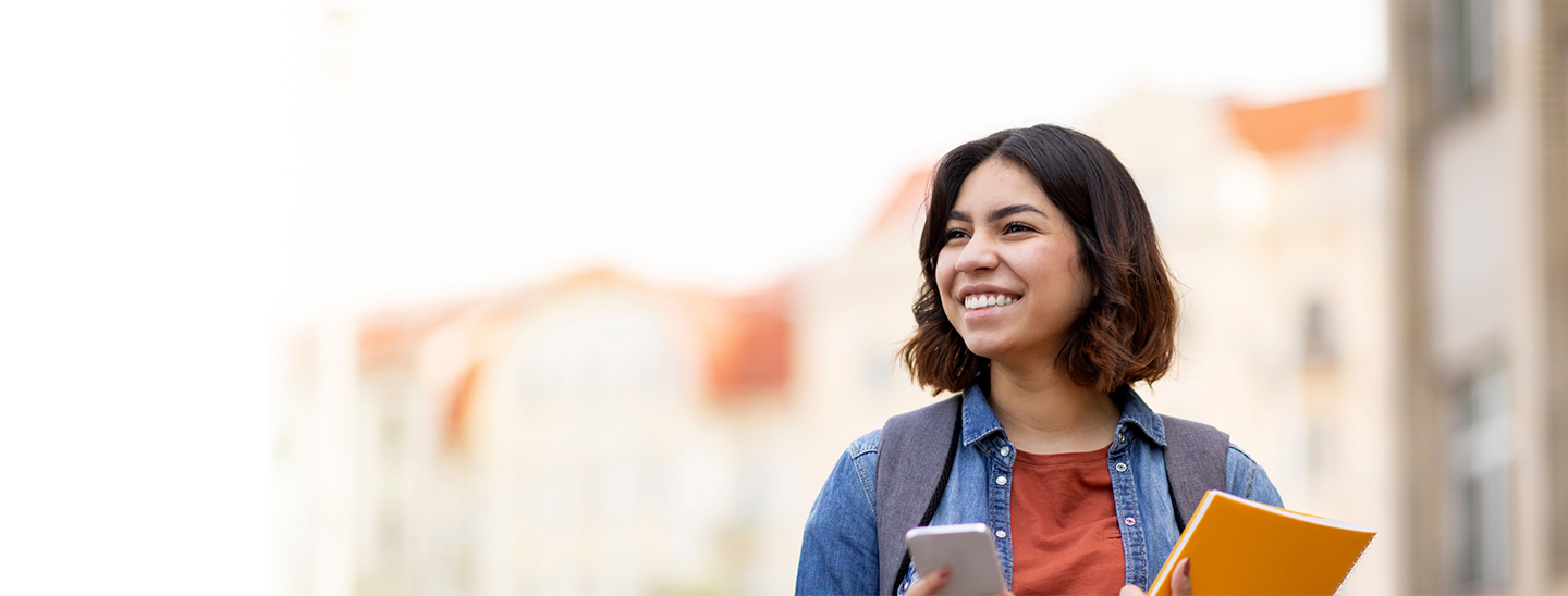 Student happy outside using phone