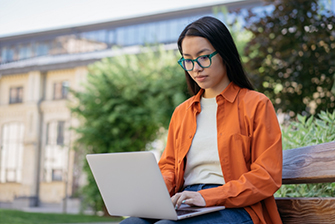 Student outside working studying alone