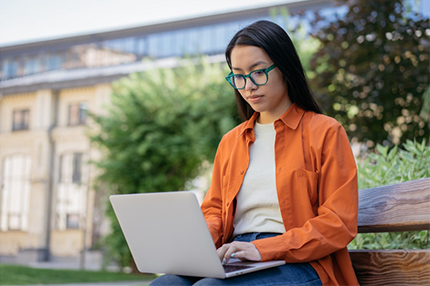 Student outside working studying alone