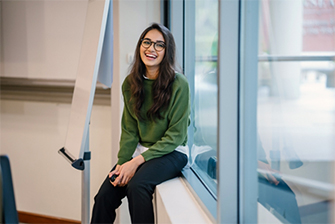 Student sitting against window