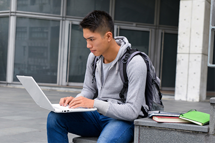 Student sitting alone laptop