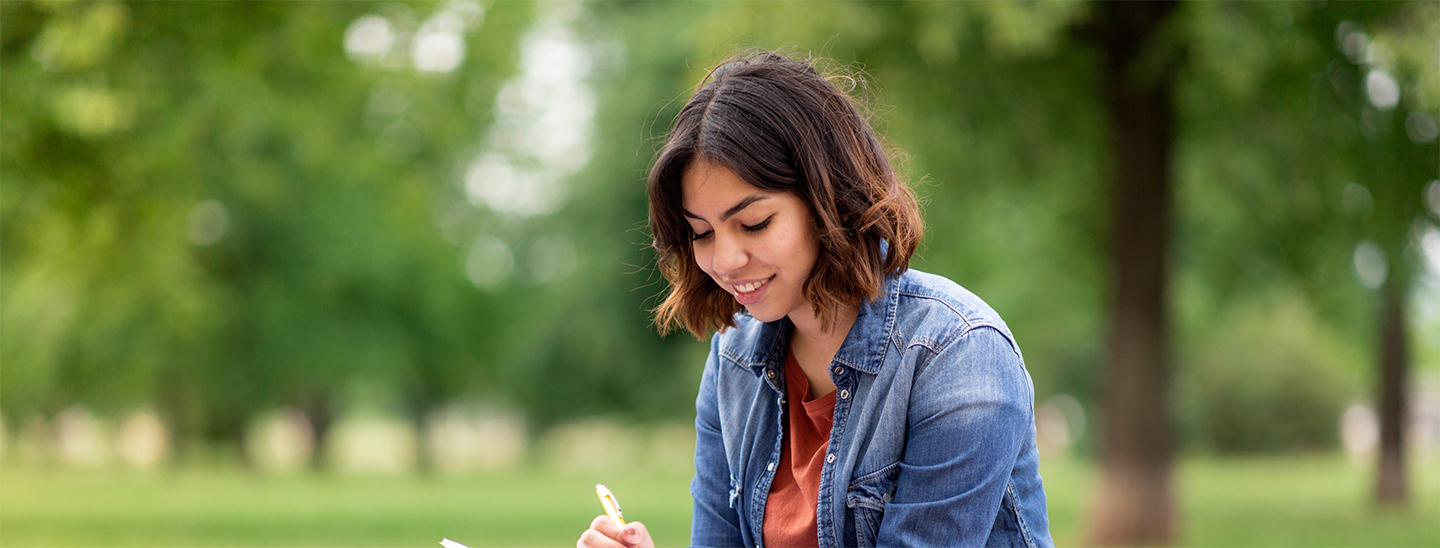 Student sitting outside on grass