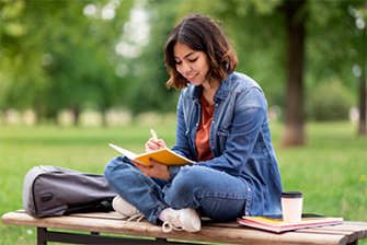 Student sitting outside on grass