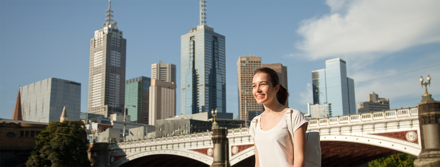 Student walking along river bridge